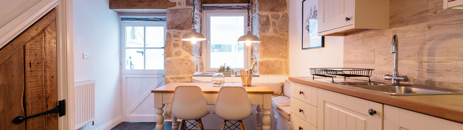 Kitchen with an exposed stone wall in a two bedroom luxury holiday cottage in St Ives Cornwall by Beachspoke